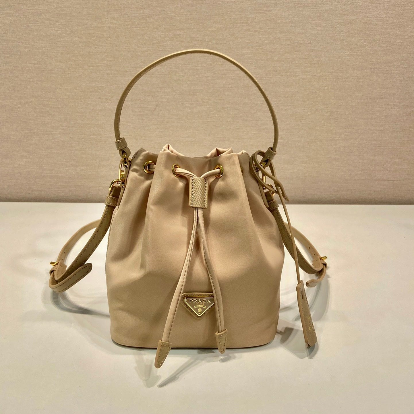 BUCKET BAG 19 IN BEIGE RE-NYLON AND SAFFIANO LEATHER HANDLE